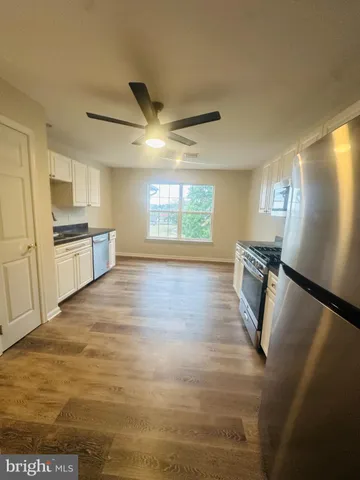 a kitchen with stainless steel appliances granite countertop a refrigerator a stove and a sink