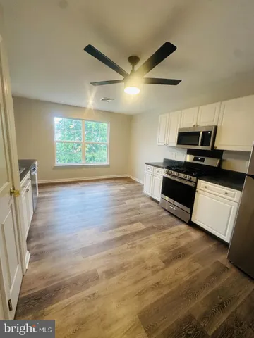 a kitchen with wooden floors and appliances