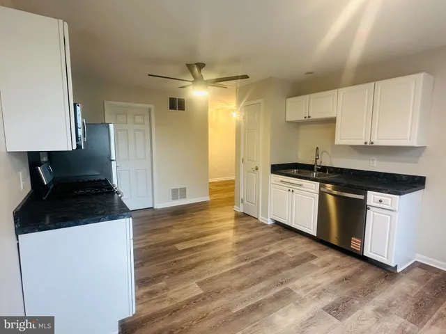 a kitchen with a sink a stove and cabinets