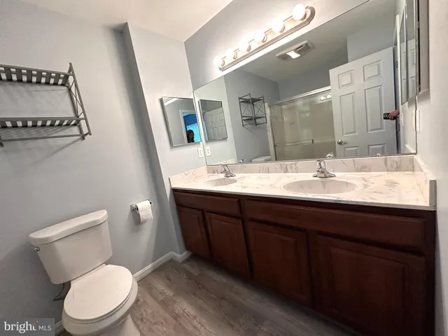 a bathroom with a toilet a sink a mirror and vanity