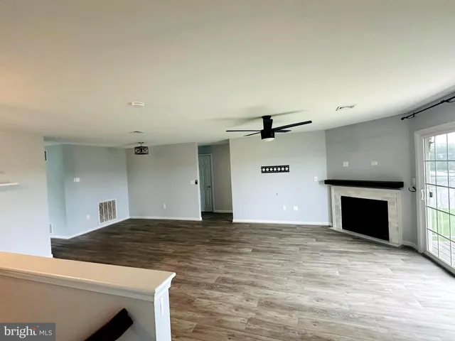 a view of a livingroom with a kitchen and a fireplace