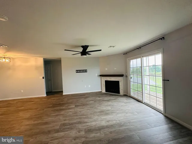an empty room with windows and fireplace