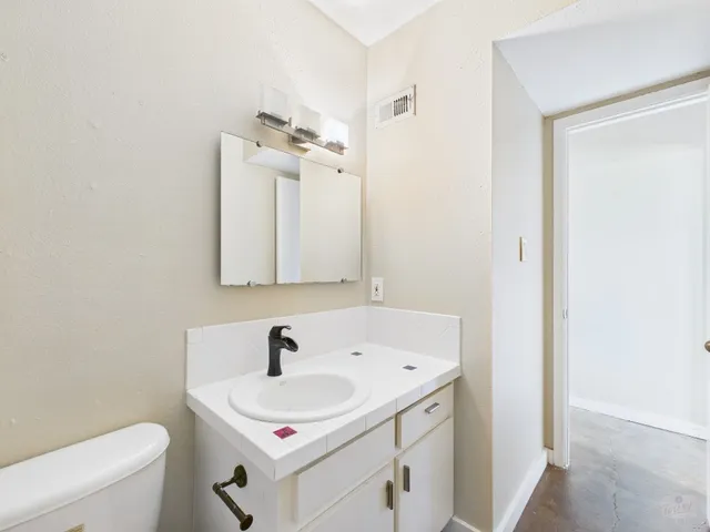a bathroom with a sink a toilet and mirror