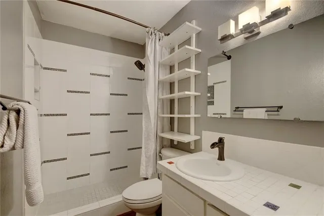 a bathroom with a sink toilet and shower
