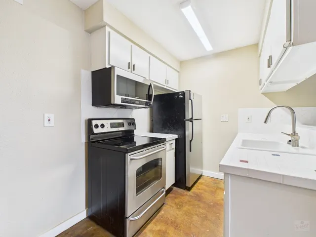 a kitchen with stainless steel appliances a stove microwave and a sink
