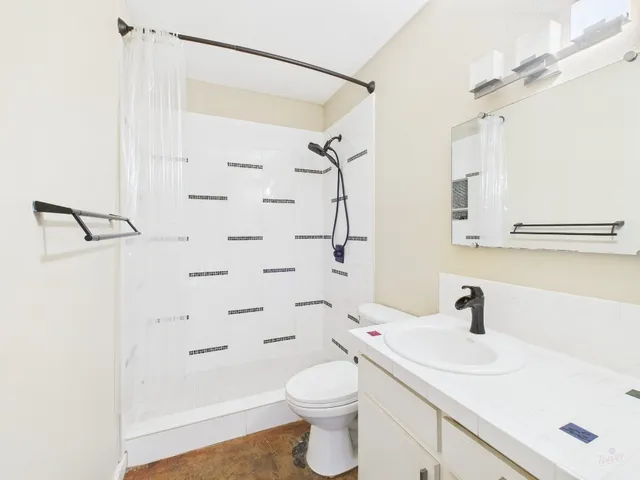 a bathroom with a sink a toilet and shower