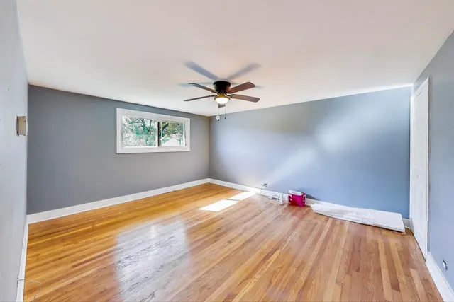 a view of a room with wooden floor and a ceiling fan