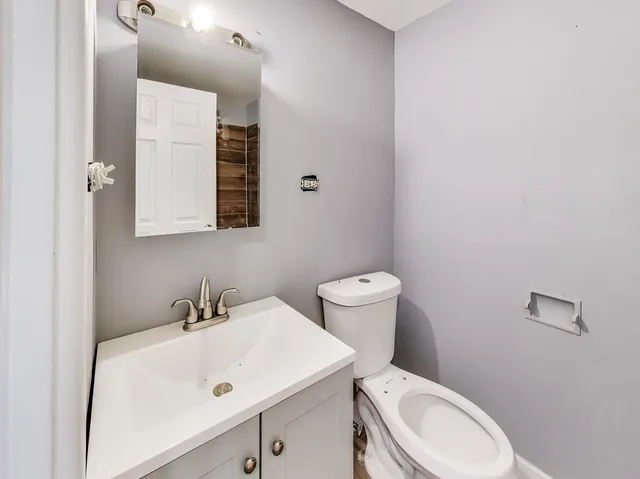 a bathroom with a sink a toilet and mirror