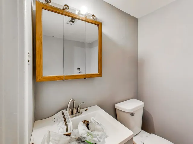 a bathroom with a sink a toilet and mirror