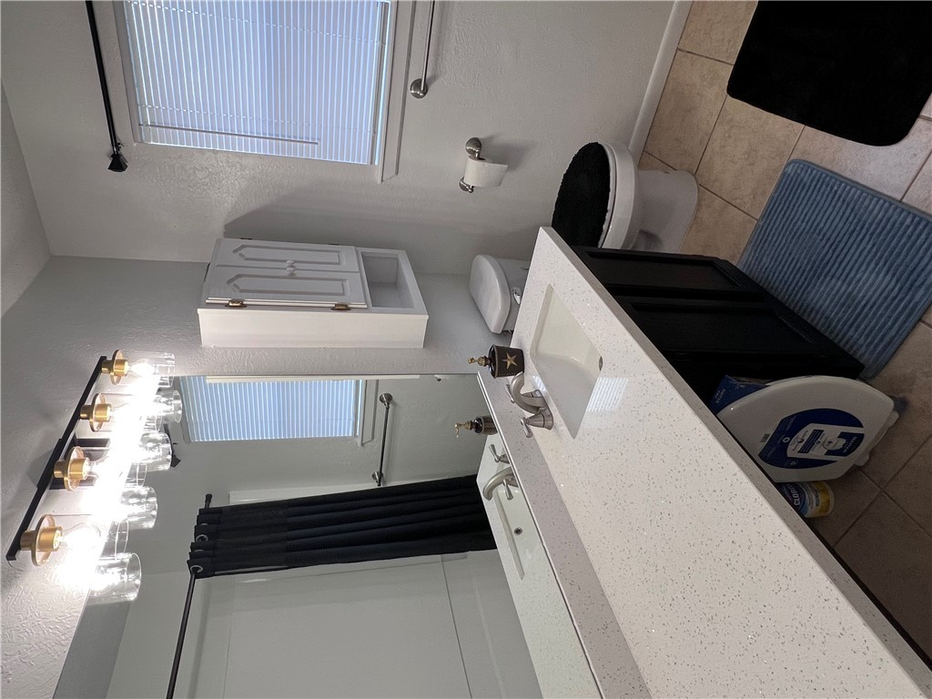 4507 Carter Creek Parkway, Unit 2 Bryan, TX 77802 - Photo 18 of 26 a bathroom with a sink a toilet and a mirror