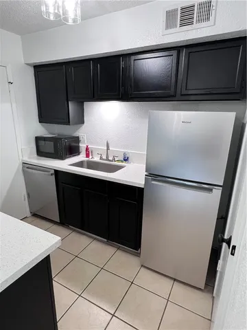 a kitchen with stainless steel appliances a sink dishwasher stove and cabinets