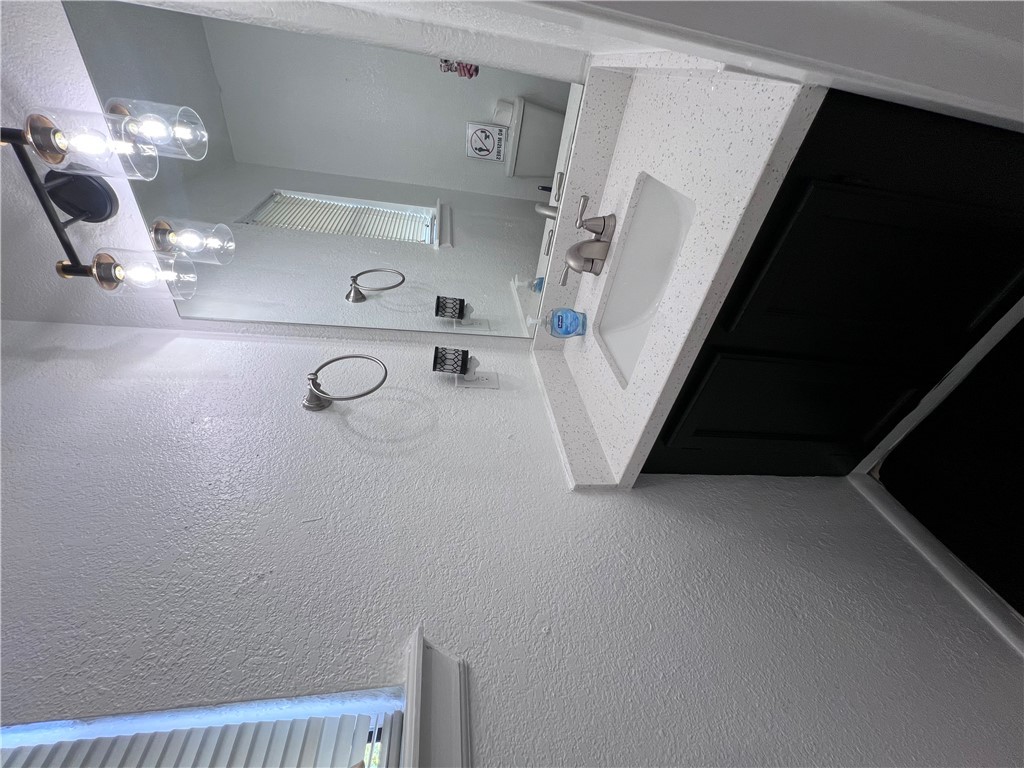 4507 Carter Creek Parkway, Unit 2 Bryan, TX 77802 - Photo 9 of 26 a bathroom with a sink a light fixture and a mirror