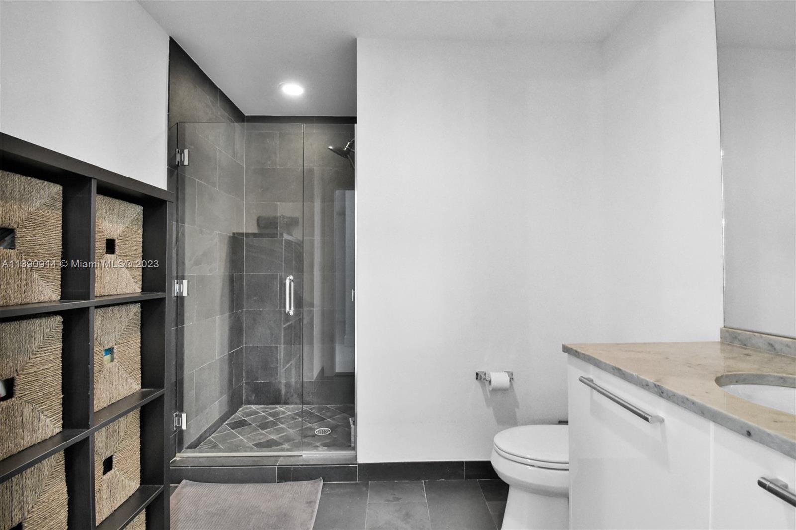 900 Biscayne Boulevard, Unit 4510 Miami, FL 33132 - Photo 24 of 48 a bathroom with a granite countertop sink a toilet and a shower