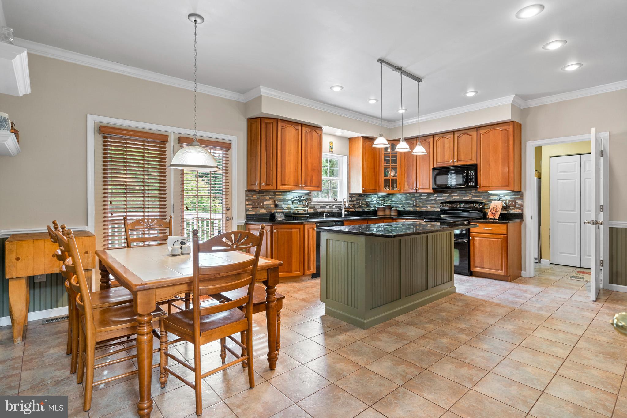 7950 Hampton Way Owings, MD 20736 - Photo 25 of 48 a kitchen with stainless steel appliances granite countertop a stove top oven a sink dishwasher a dining table and chairs with wooden floor