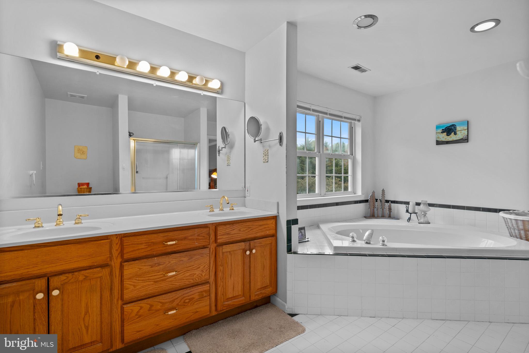 7950 Hampton Way Owings, MD 20736 - Photo 32 of 48 a bathroom with a tub a sink double vanity and a mirror