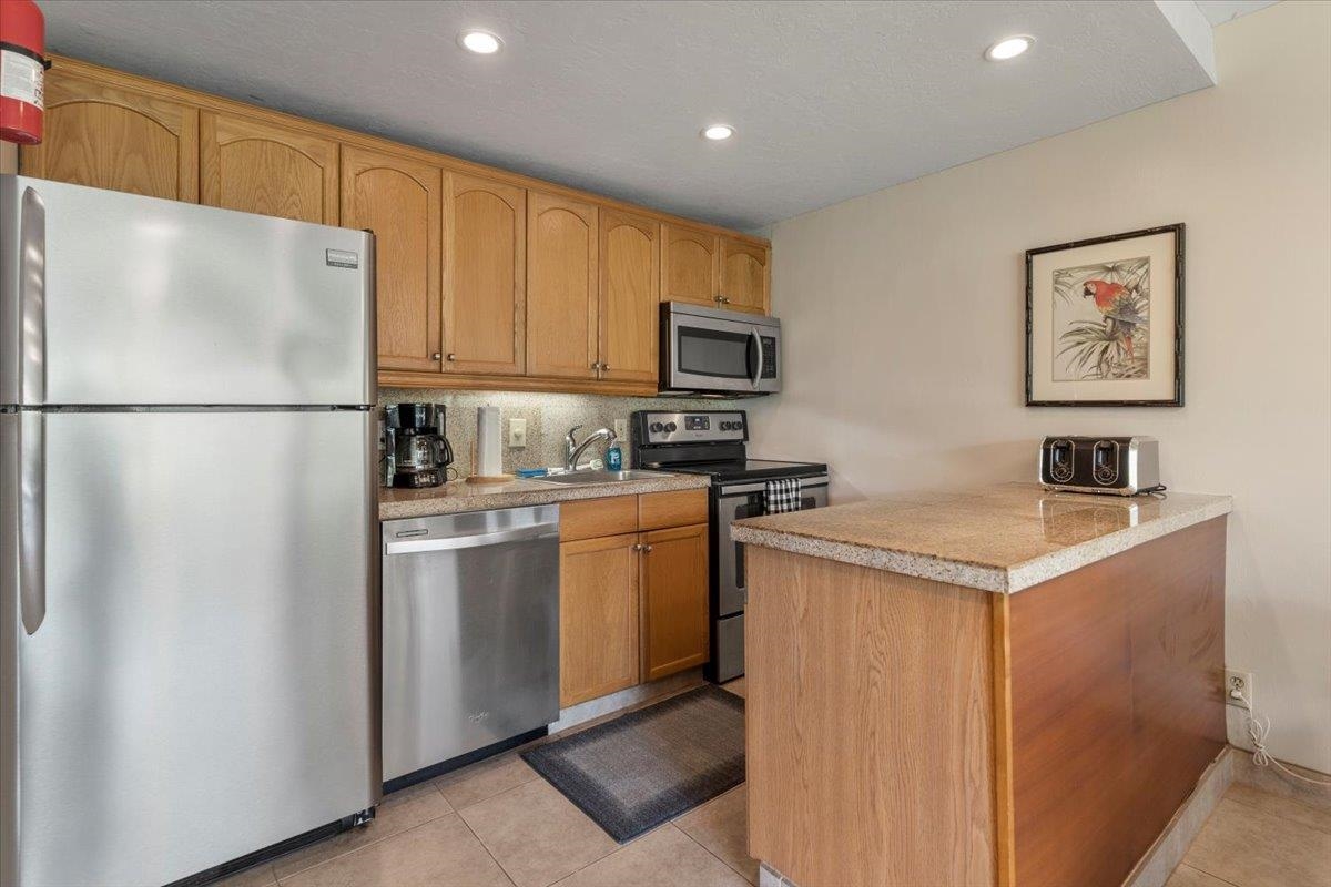 2495 South Kihei Road, Unit 254 Kihei, HI 96753 - Photo 13 of 30 a kitchen with a refrigerator a stove a microwave a sink and a refrigerator