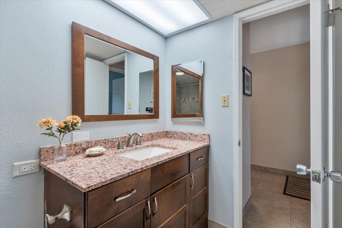 2495 South Kihei Road, Unit 254 Kihei, HI 96753 - Photo 26 of 30 a bathroom with a granite countertop sink and a mirror