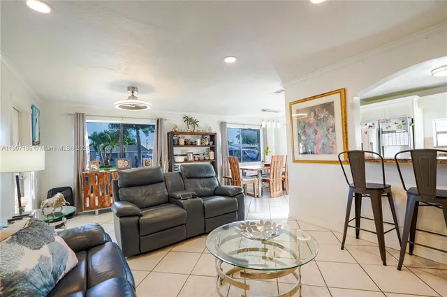 a living room with furniture potted plant and a large window