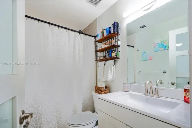 a bathroom with a sink toilet and a mirror