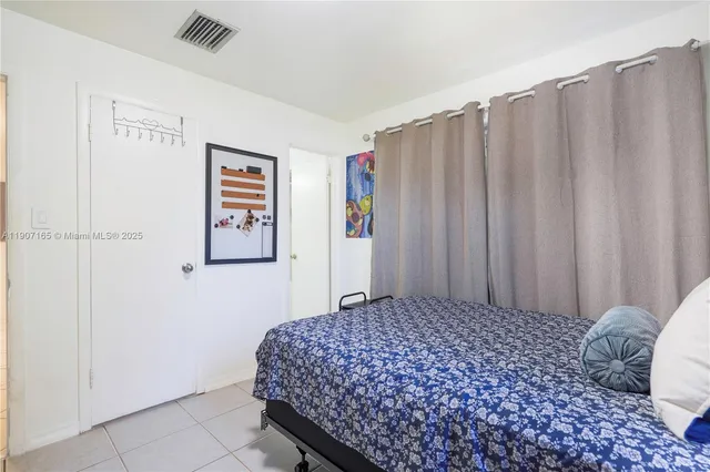 a bedroom with a bed and a curtain