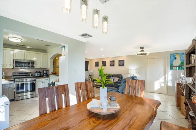 a view of a dining room with furniture a chandelier and wooden floor