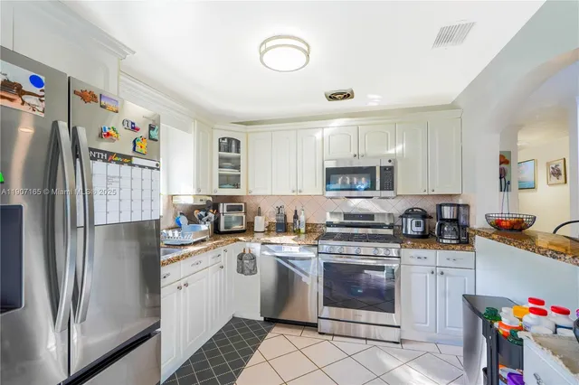 a kitchen with stainless steel appliances granite countertop a refrigerator sink and cabinets