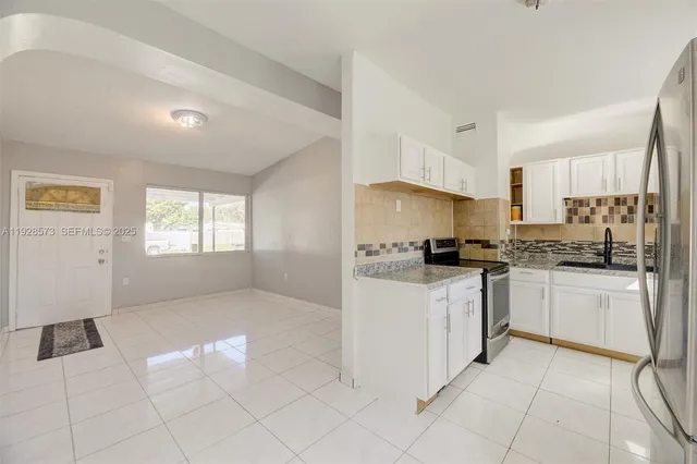 a kitchen with granite countertop white cabinets and white appliances