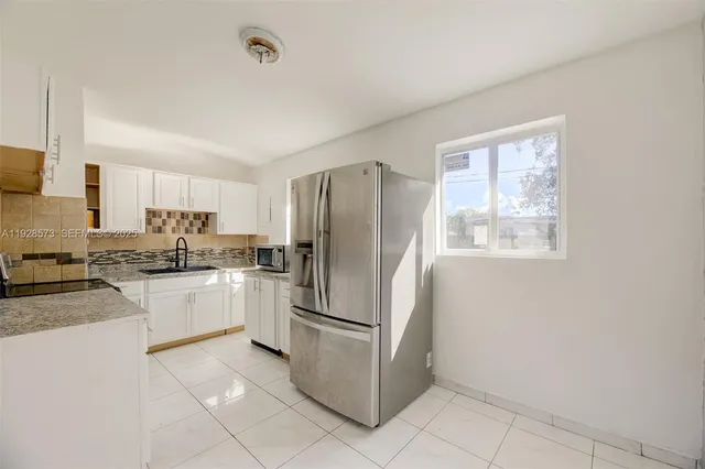 a kitchen with a refrigerator sink and microwave