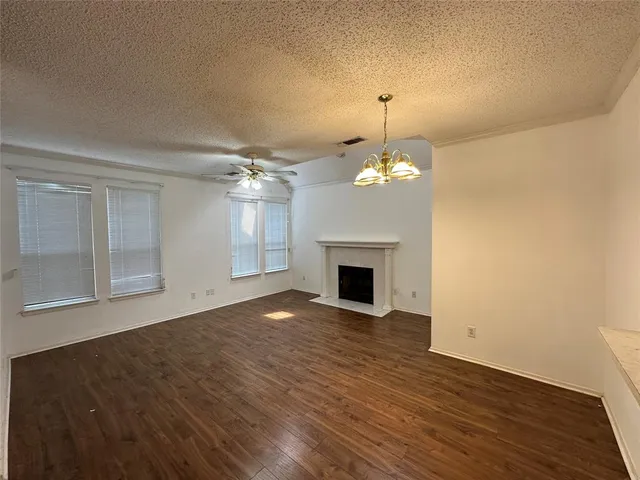 a view of empty room with wooden floor fireplace and window