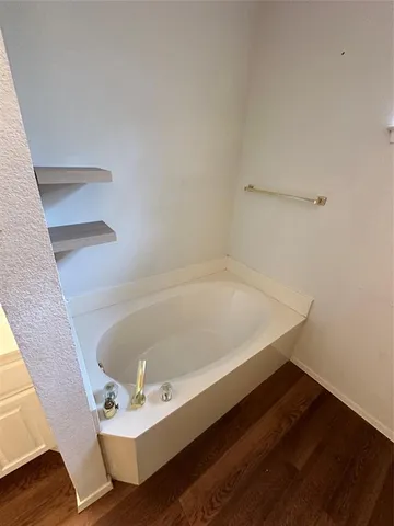 a bath tub sitting next to a white sink and vanity