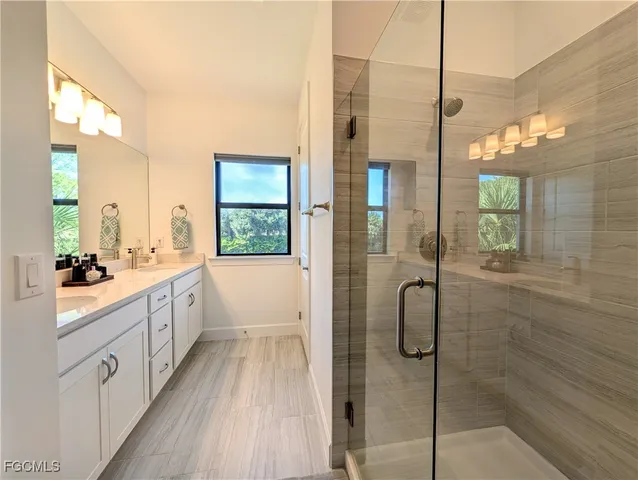a bathroom with a double vanity sink toilet and shower