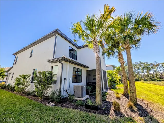 a front view of a house with a yard and potted plants