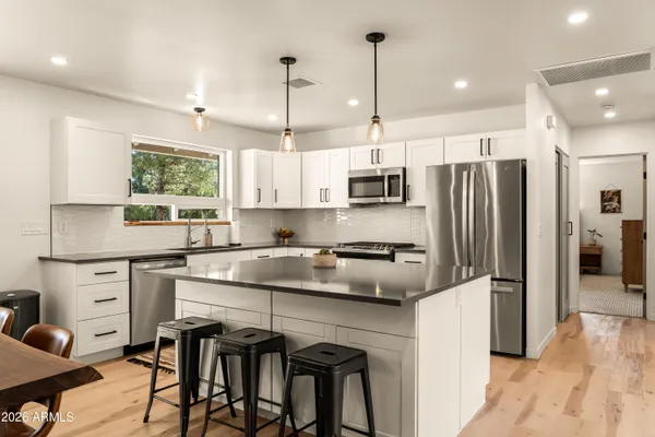 a kitchen with stainless steel appliances granite countertop a stove refrigerator sink and cabinets