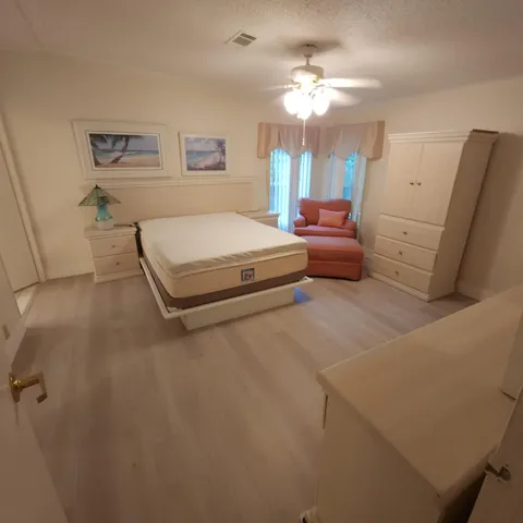 a spacious bedroom with a bed and a chandelier