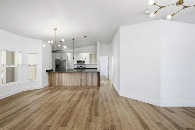 a kitchen with stainless steel appliances granite countertop a refrigerator and a sink