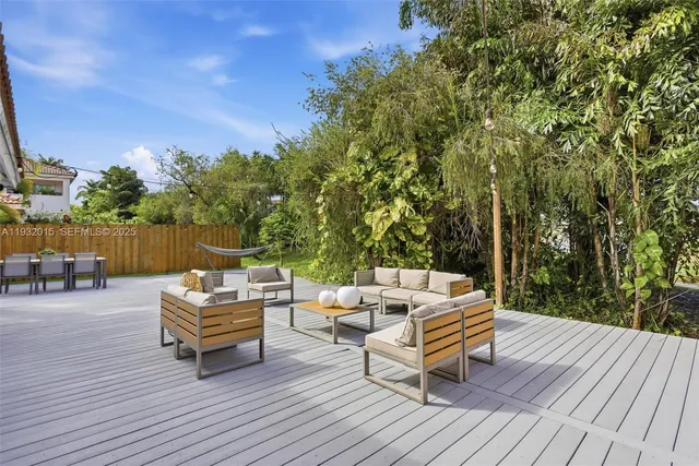 a backyard of a house with wooden floor and outdoor seating