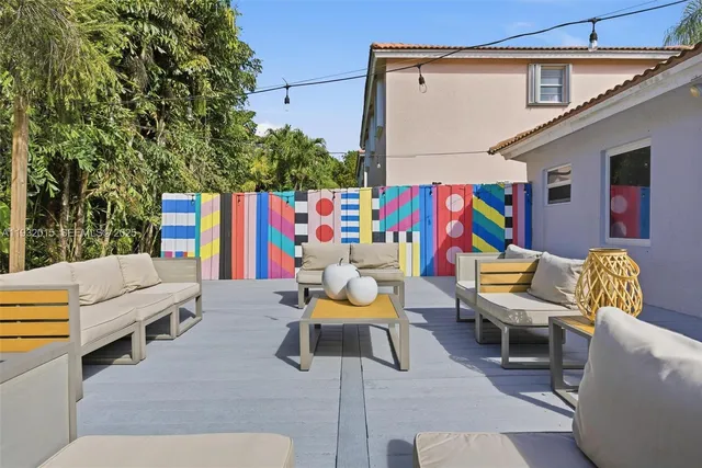 a living room with couches chairs and kitchen view with wooden floor
