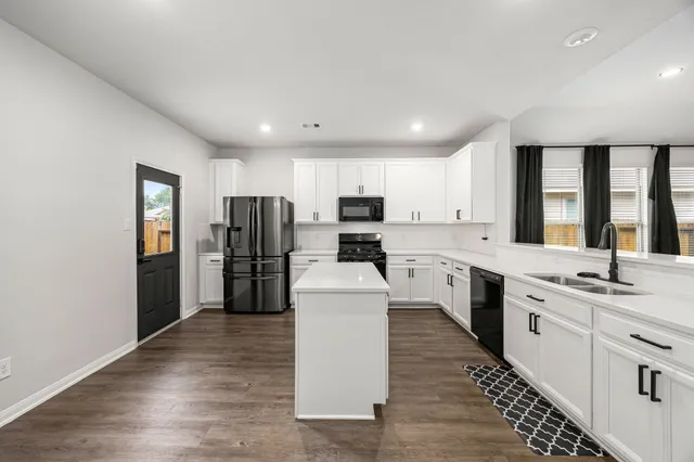 a kitchen with stainless steel appliances a refrigerator sink and cabinets
