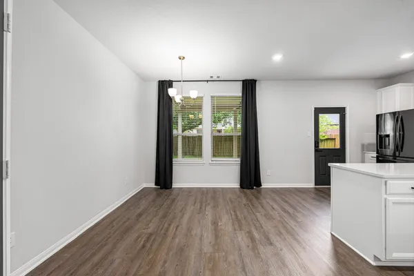 a view of a kitchen with wooden floor and a window