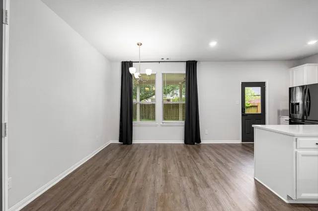 a view of a kitchen with wooden floor and a window