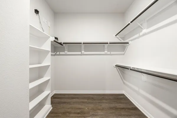 a view of walk in closet with empty racks