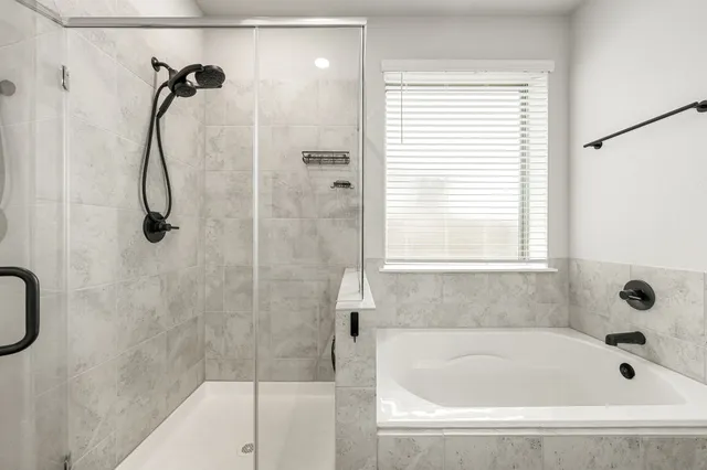 a bathroom with a bath tub with a shower