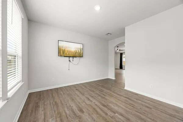 an empty room with wooden floor and windows