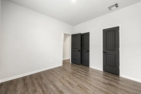 an empty room with wooden floor and closet