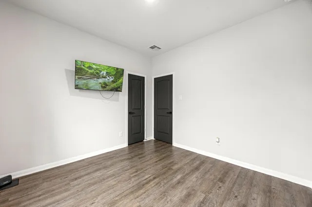a view of an empty room with wooden floor