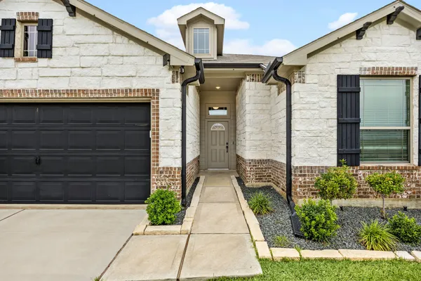 a front view of a house with a garden