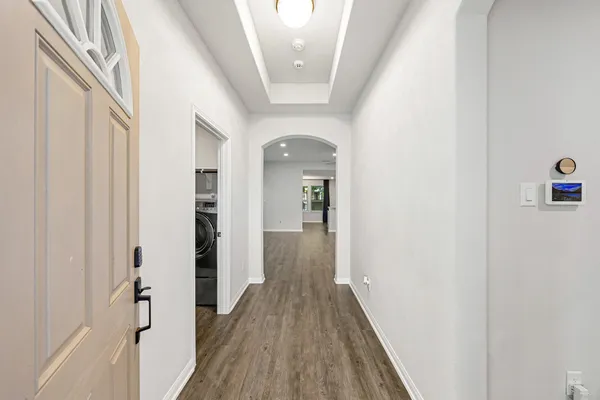a view of a hallway with wooden floor and staircase