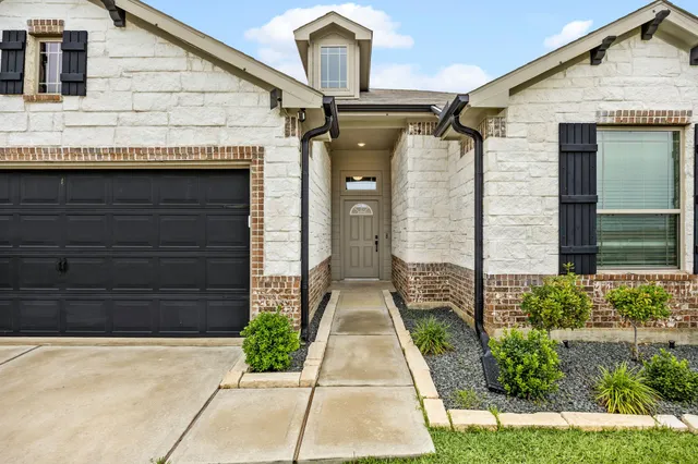 a front view of a house with a garden