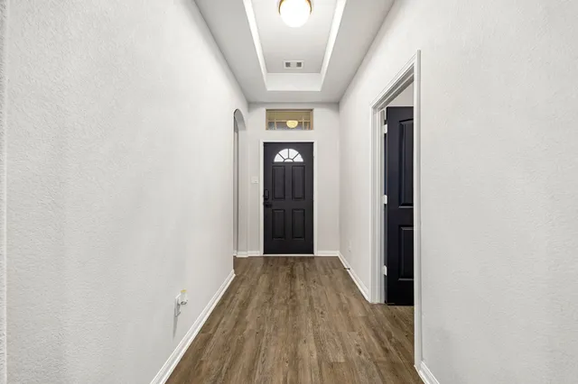 a view of a hallway with wooden floor