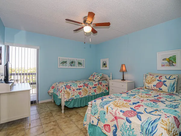 a bedroom with two beds and a chandelier